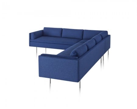 The Bolster Sofa Group, designed by BassamFellows, 2014,  offers a club chair, settee, three-seat sofa, corner and chaise lounge units and an ottoman. Available in a large selection of fabric choices, curated by Herman Miller, it has brushed stainless steel legs.
