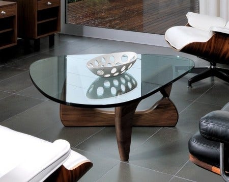 The Herman Miller Noguchi Table, designed in 1948 by Isamu Noguchi, is available in 4 finishes: black, walnut, natural cherry and white ash. Isamu Noguchi's signature appears on the edge of the glass top.