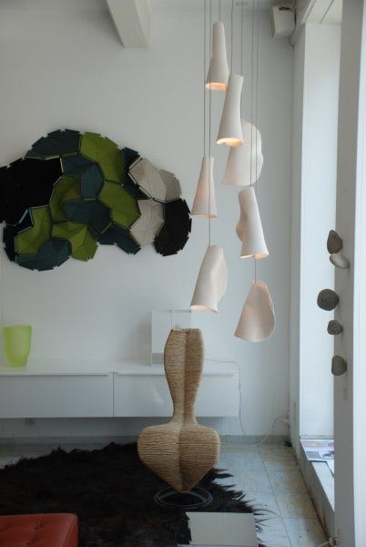 Inspired by the sporadic, perhaps discordant arrangement of barnacles on a rock surface, the 21 Series is fabricated from thin sheets of porcelain wrapped around frosted borosilicate glass trumpet-shaped diffusers.