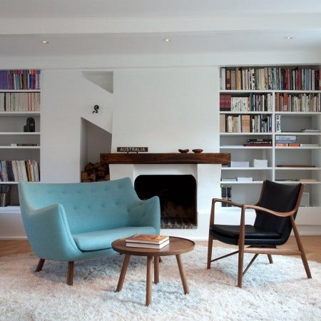 The Finn Juhl Poet Sofa, seen here with the Pelican Coffee Table, designed in 1940, was inspired by "free art". Today this sofa represents a part of Danish cultural history. The Poet Sofa is made to the finest manufacturing standards with hand-sewn upholstery and its legs come in several different wood finishes.