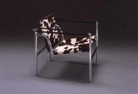 A lightweight compact sling chair, the LC1 is made of polished trivalent chrome plated or semi gloss black enamel steel frame. The seat and back are available in pony hide, cow hide or saddle leather in a wide range of colours with matching arms.
