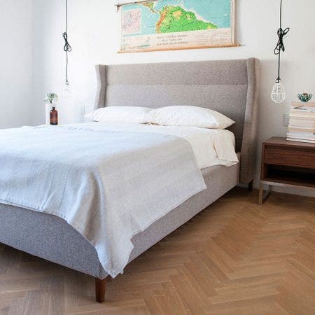 The Carmichael Bed fuses traditional and contemporary sensibilities, bringing clean, modern lines to a classic style. The design features a fully upholstered headboard, footboard and side rails, with elegant, tapered solid wood legs. The bed includes a sturdy mattress suspension system which eliminates the need for a box spring.