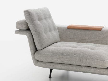 the slim, fabric-covered body is doubly angled to form a cascading seat, backrest and rearward ledge. The body is supported at two points under each end of the seat surface and behind the backrest by a bridge-like aluminium base frame, making the sofa appear to float above the floor.